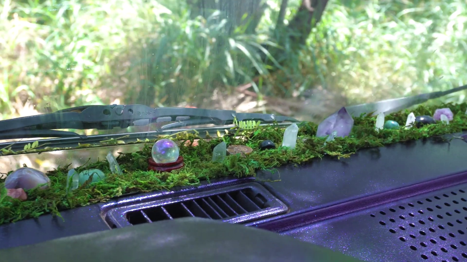 the dashboard of a car is decorated with moss and crystals