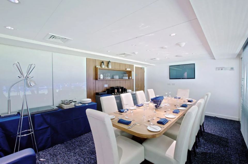 a dining room with a long table and white chairs