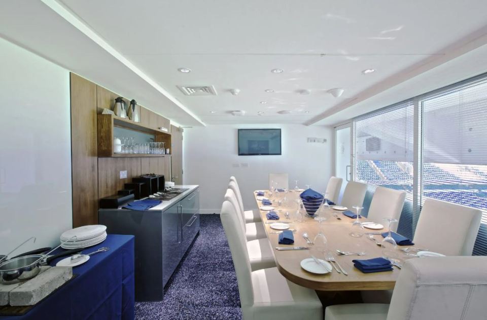 a dining room with a long table and white chairs