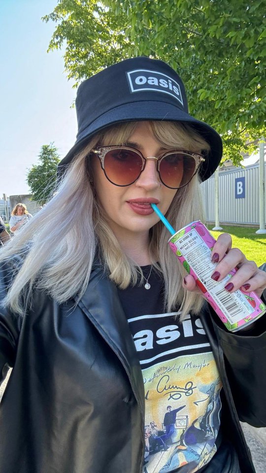 a woman wearing a black oasis hat and sunglasses