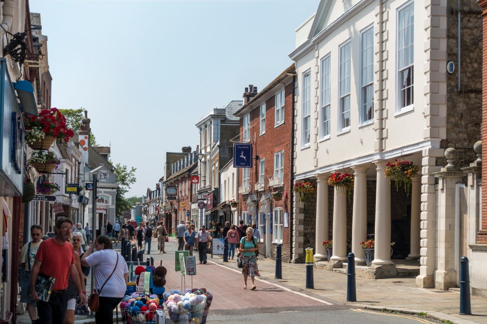 people walking down a street with a sign that says ' a ' on it