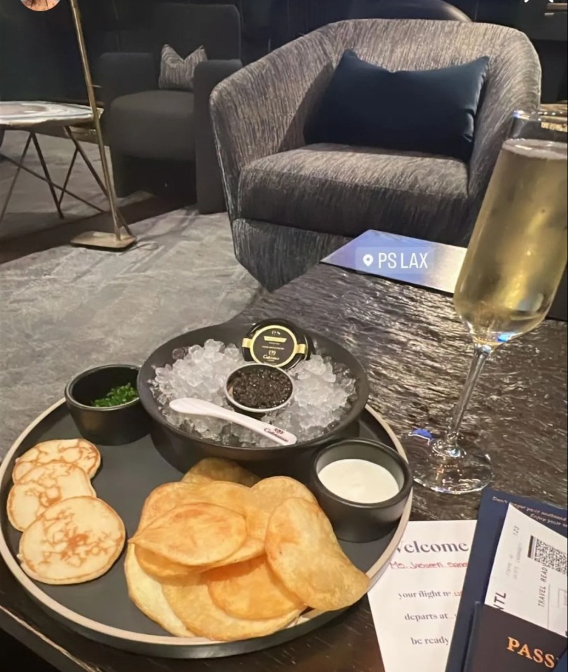 a phone screen shows a tray of food and a glass of champagne