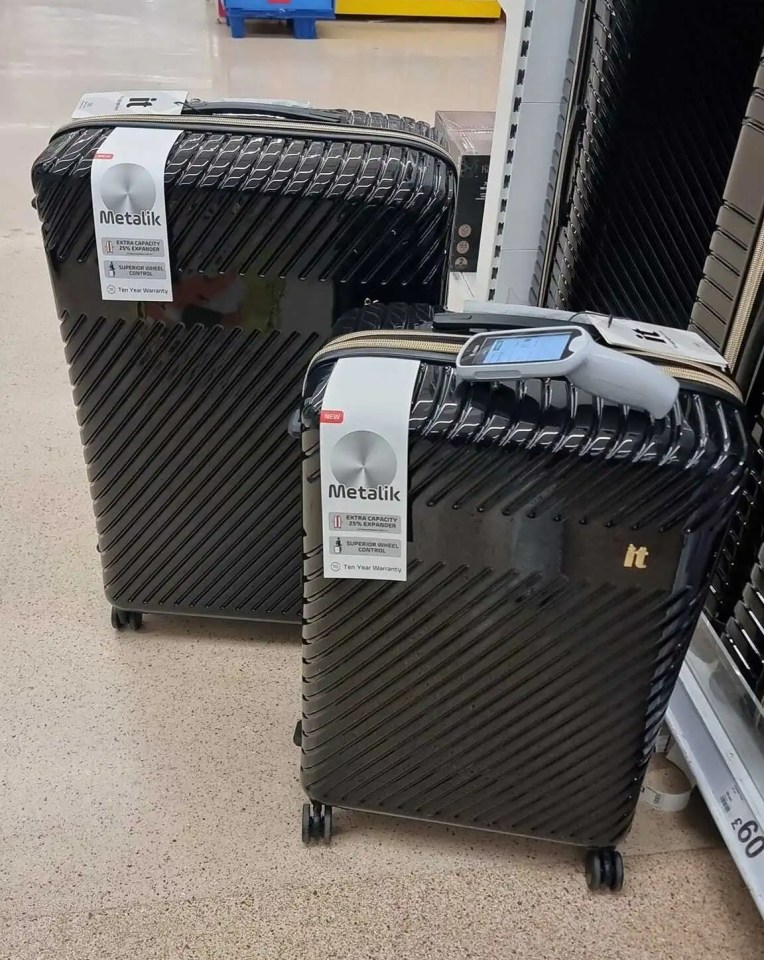 two metalik suitcases are sitting on the floor in a store