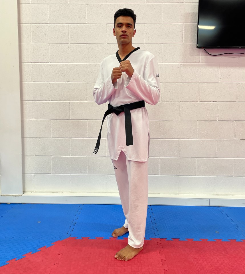 a young man in a taekwondo uniform with a black belt