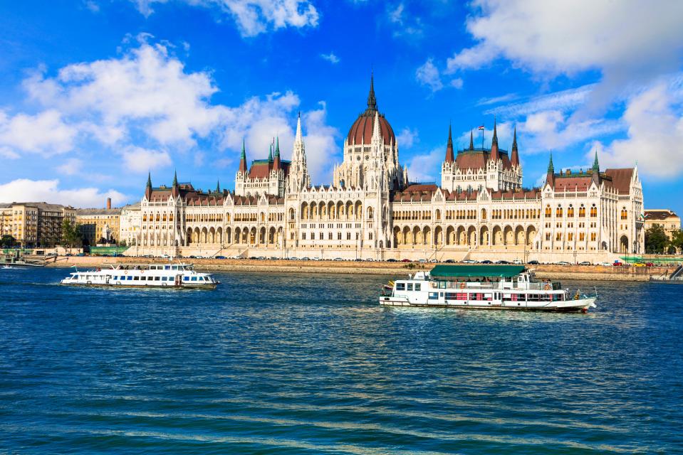 two boats are in the water in front of a large building