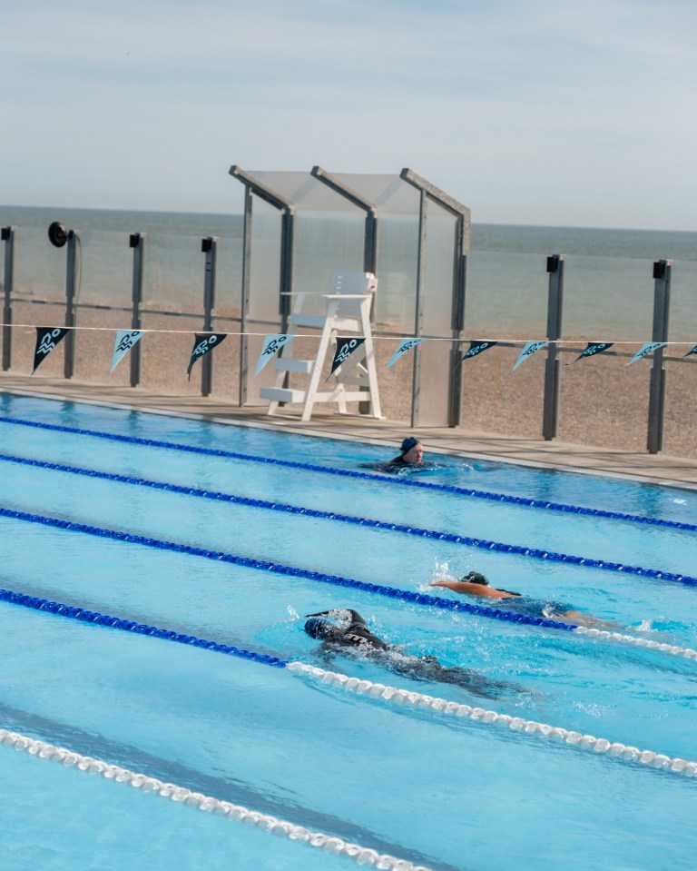 people are swimming in a pool with flags that say go