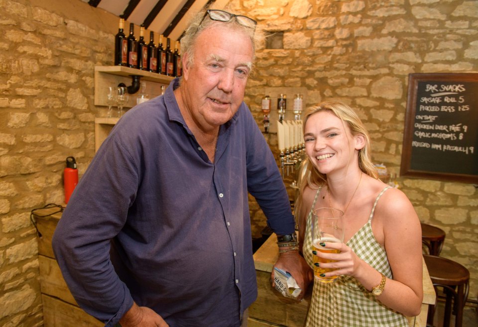 a man and a woman standing in front of a sign that says bar snacks