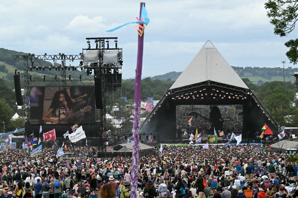 a large crowd of people are gathered at a music festival