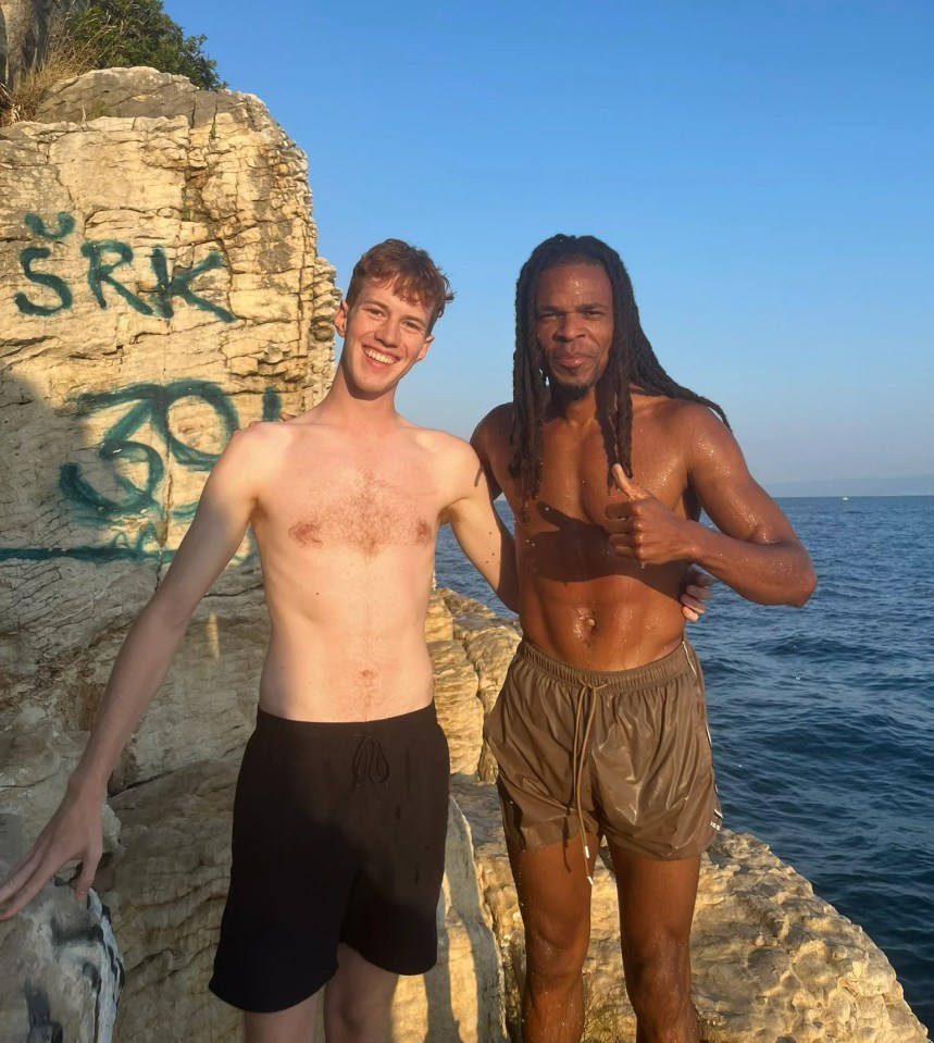 two men standing in front of a rock that says srk on it