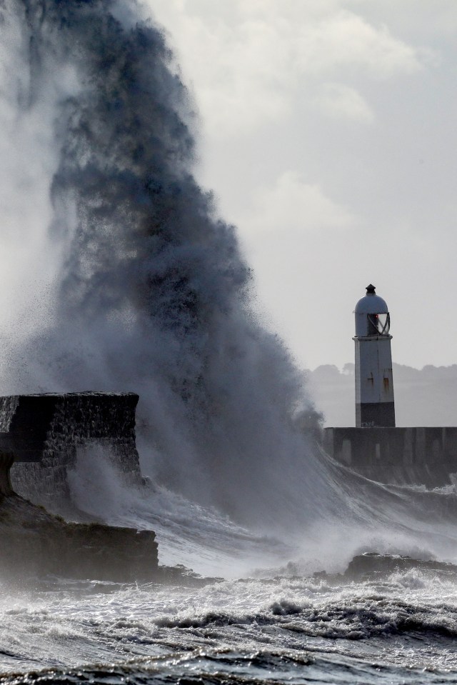 Two men watch the choppy waves in Porthcawl