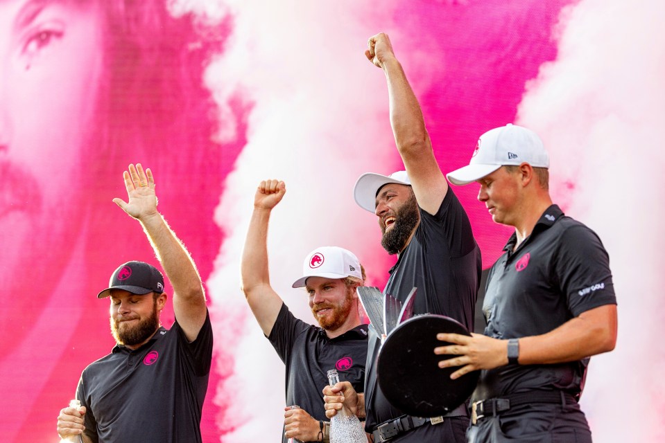 a group of men are standing in front of a pink background