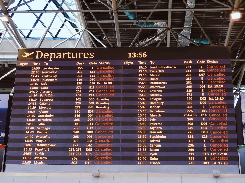 a departures board at an airport shows that many flights have been cancelled