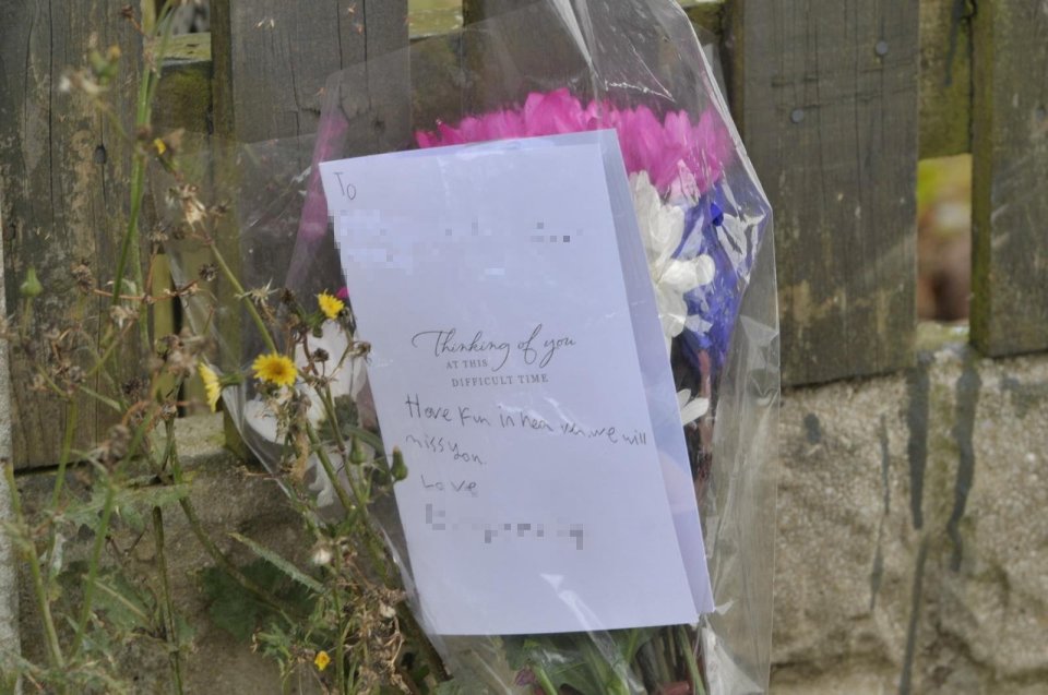 a bouquet of flowers with a card that says thinking of you at this difficult time