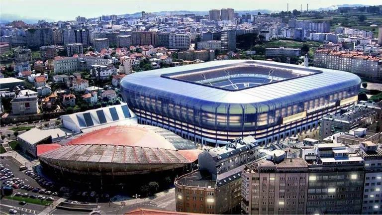 an aerial view of a large stadium in a city