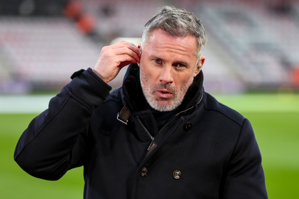 a man in a black coat adjusts his ear buds