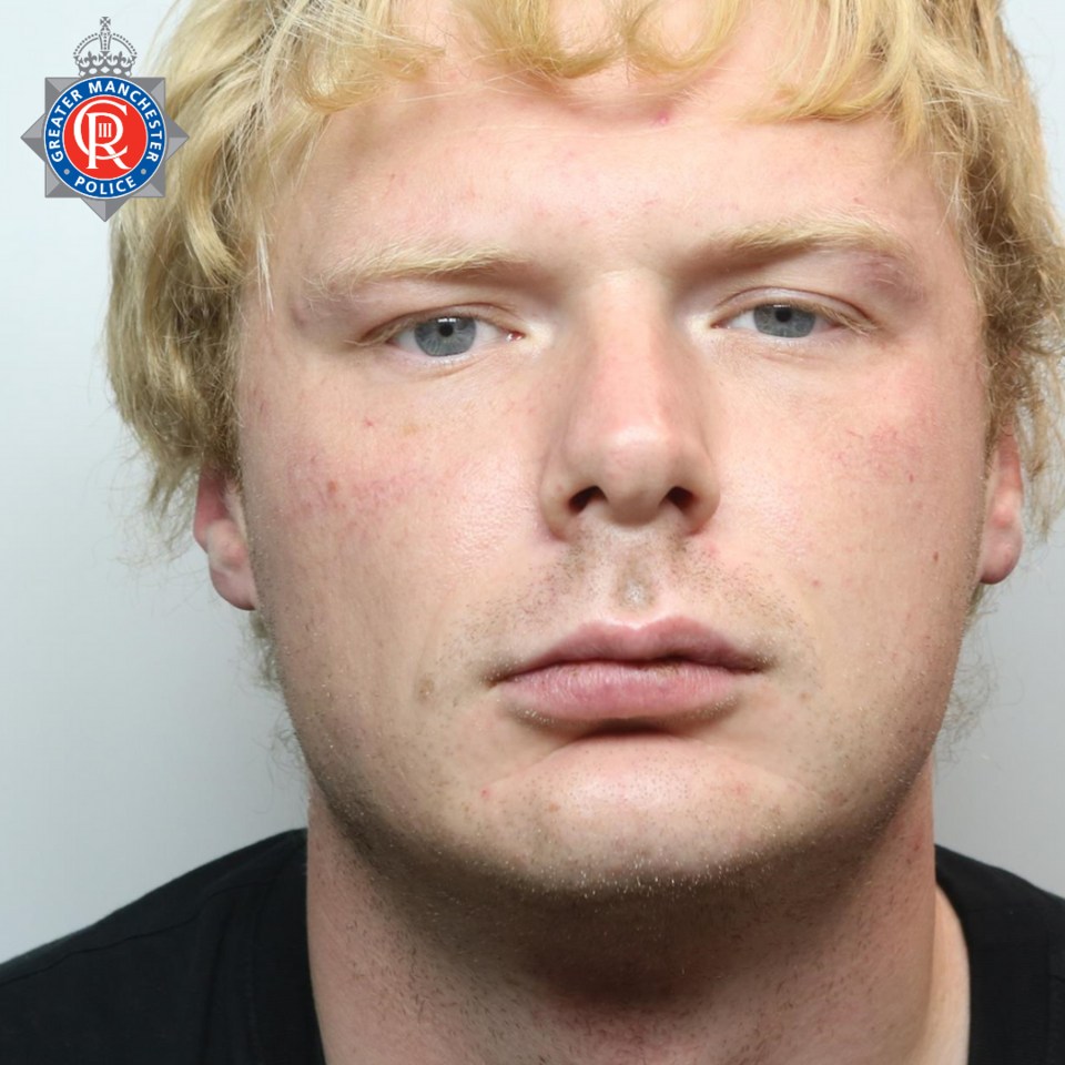 a man with blonde hair has a greater manchester police badge on his chest