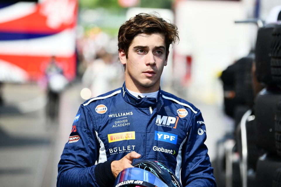 a young man wearing a williams driver academy jacket