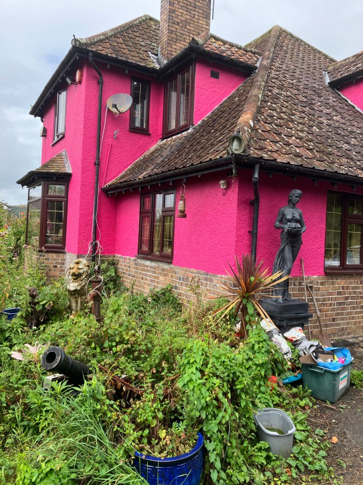 a pink house with a statue in front of it