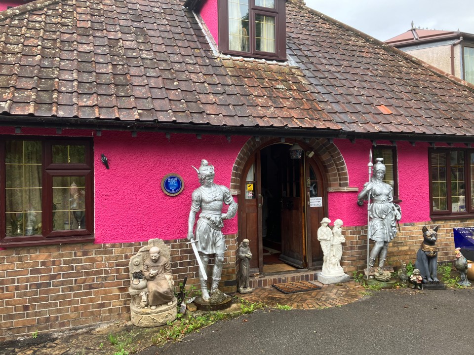 a pink house with a blue plaque on it