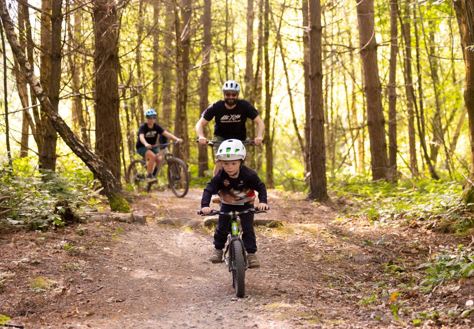 a boy wearing a helmet is riding a bike in the woods