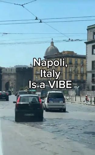 a car is driving down a busy street in napoli , italy .