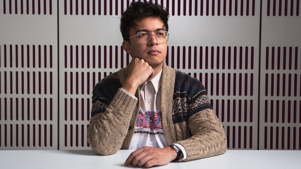 a man wearing glasses and a sweater with an american flag on it