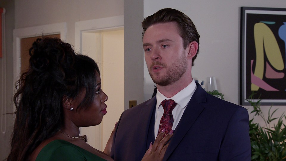 a man in a suit and tie stands next to a woman in a green dress