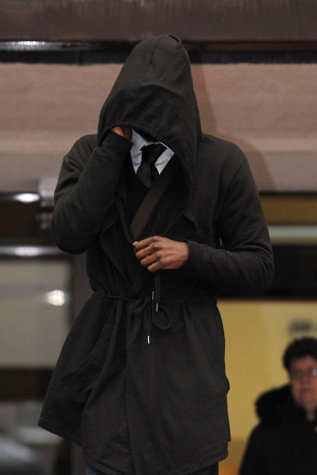 a man covering his face with a hooded jacket