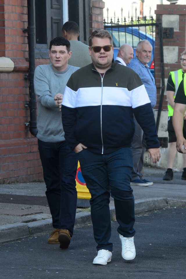 a man wearing sunglasses is walking down the street