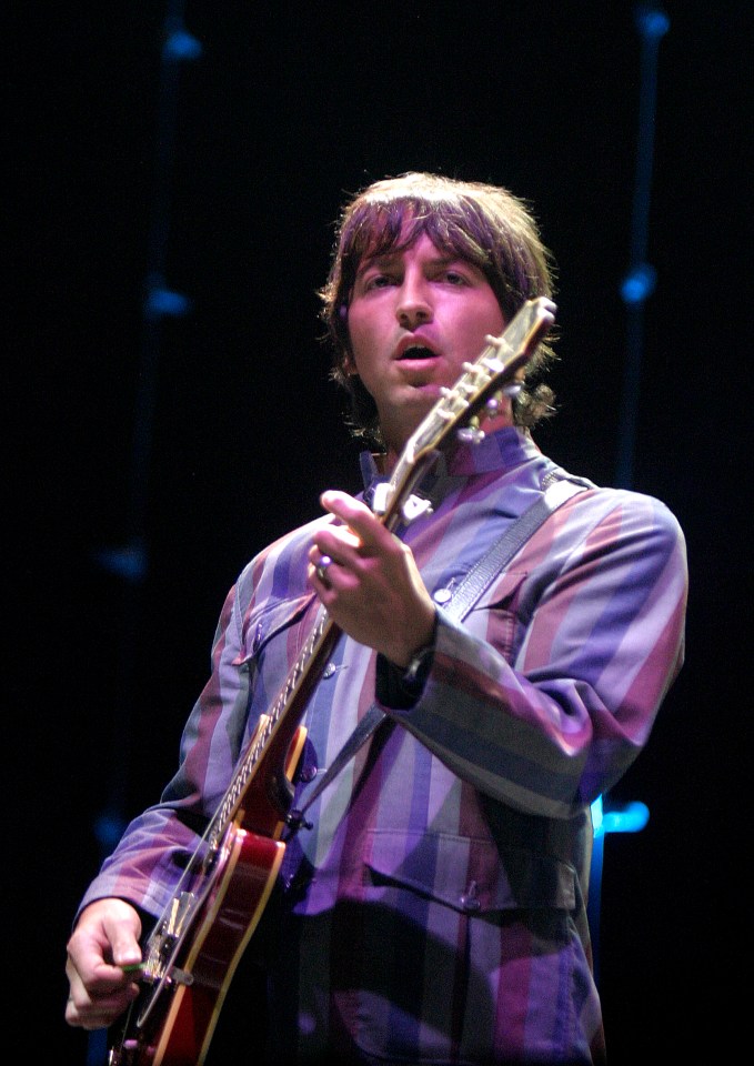 a man in a striped shirt is playing a guitar