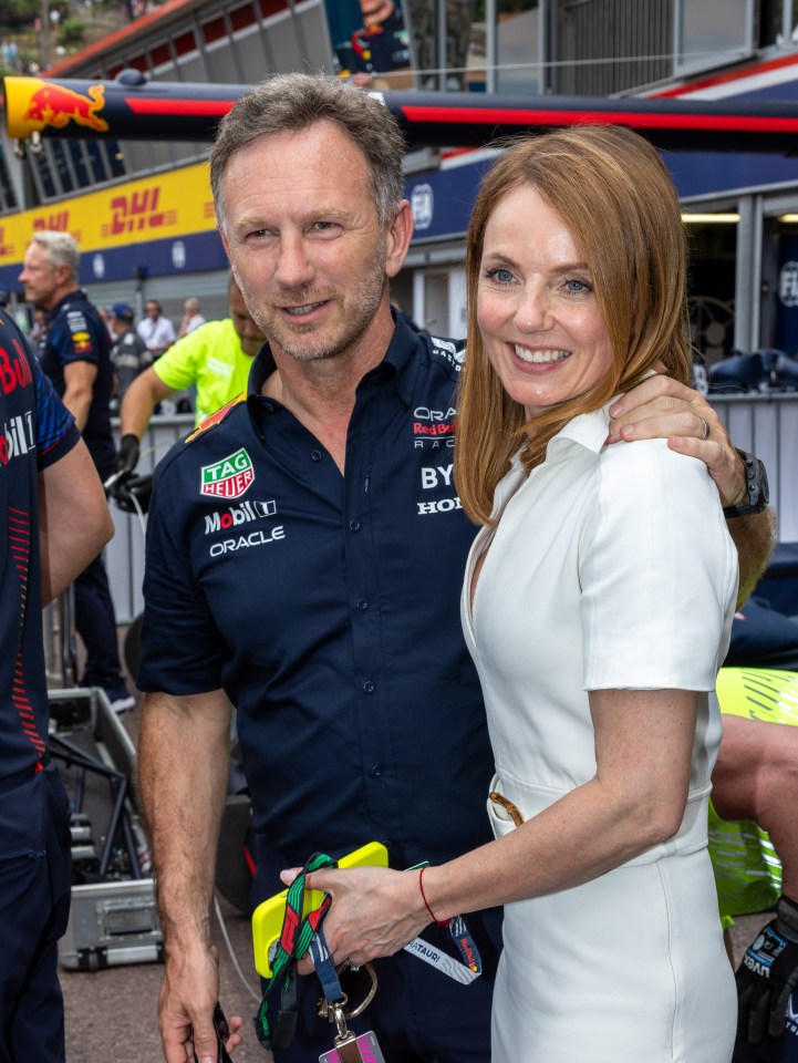 a man wearing a tag heuer shirt stands next to a woman in a white dress