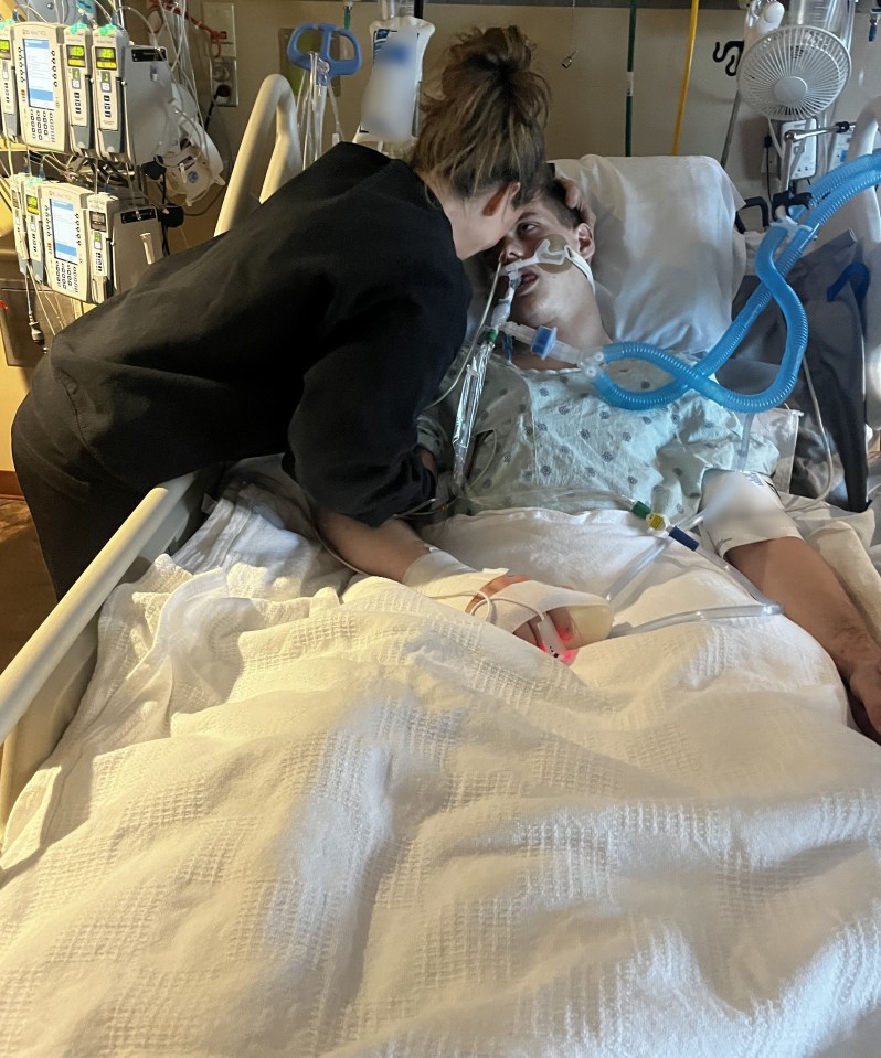 a woman kisses a man in a hospital bed with an oxygen mask on