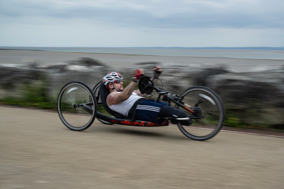 a man wearing a helmet is riding a hand bike