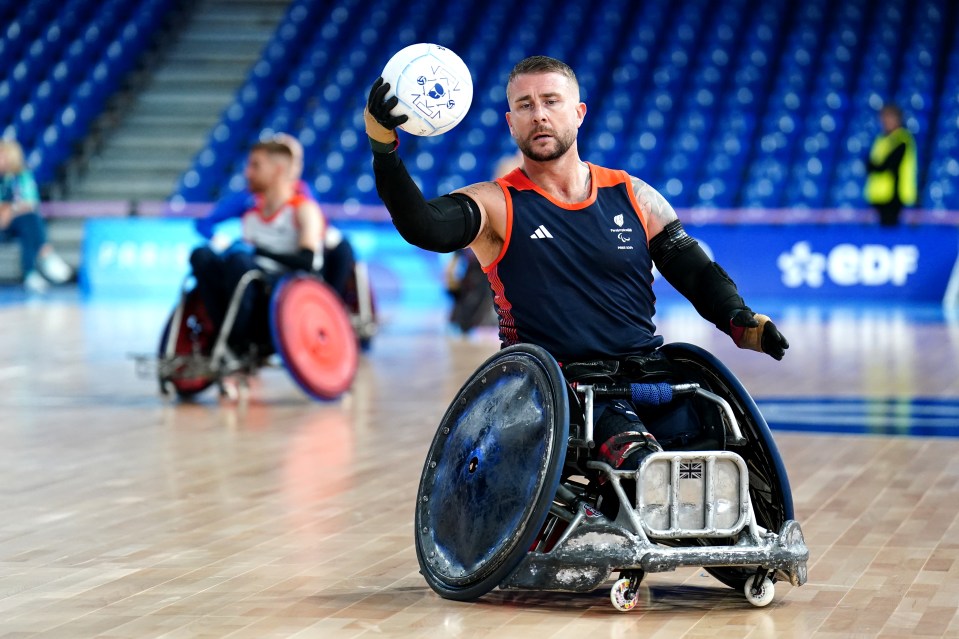 a man in a wheelchair is holding a frisbee in front of a sign that says edf