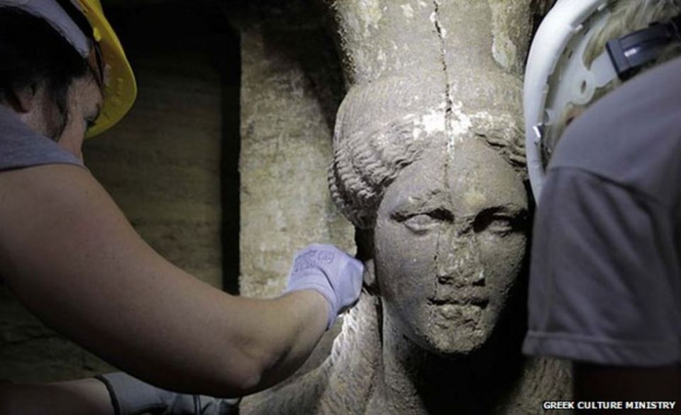 An archaeologist working on the face of one of the caryatids