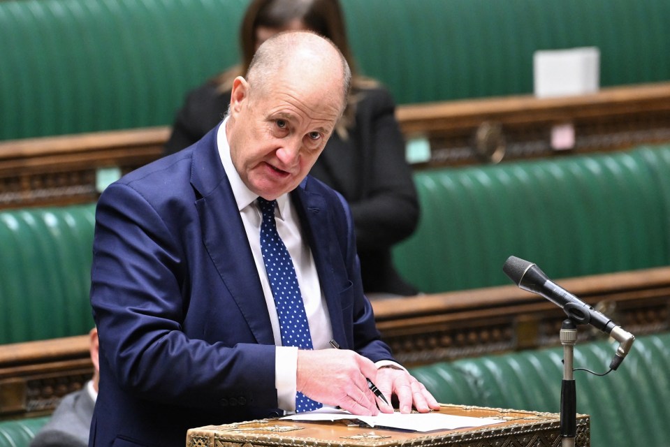 a man in a suit and tie is speaking into a microphone