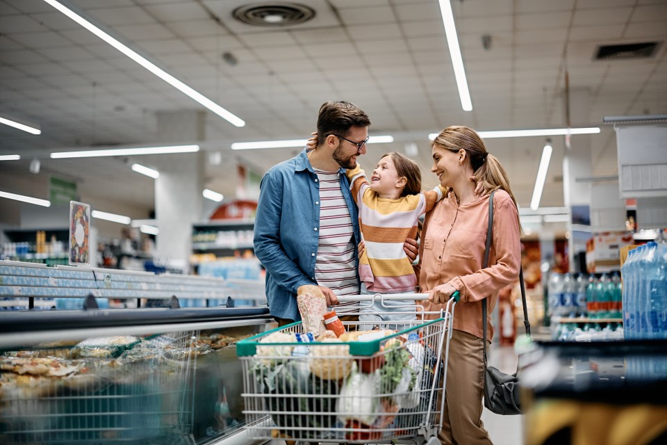 Happy embraced family enjoying in shopping at supermarket.