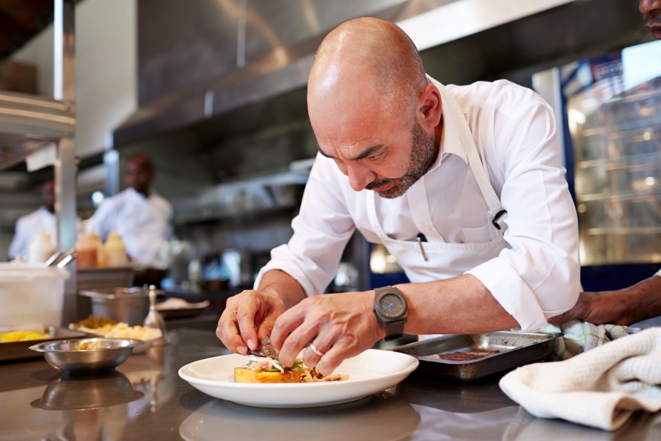 a chef prepares a plate of food in a kitchen