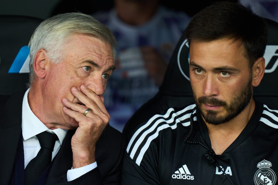 a man wearing an adidas shirt sits next to another man