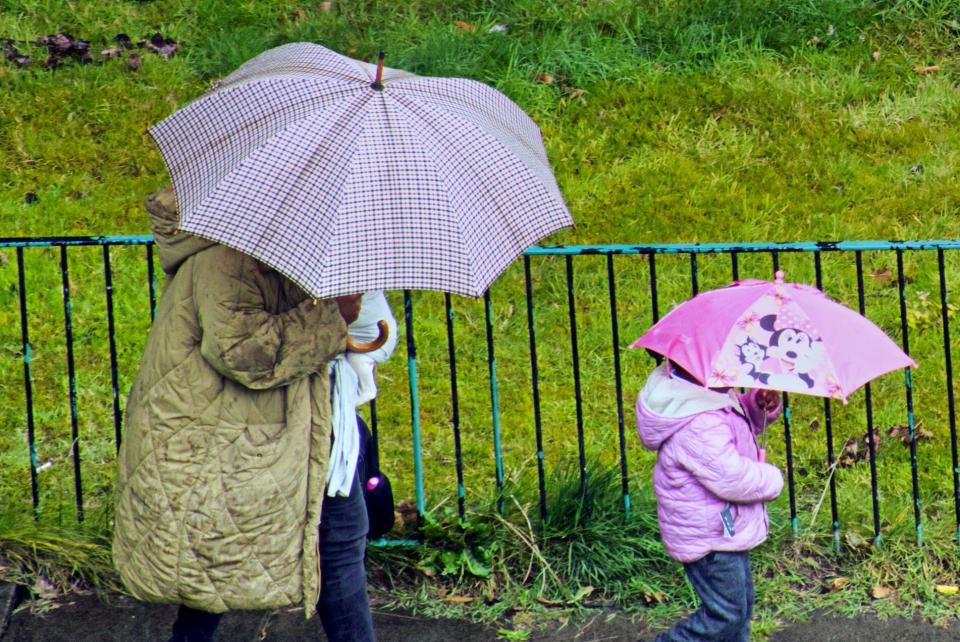 A mum and daughter battle the downpours in Glasgow, Scotland, on Tuesday