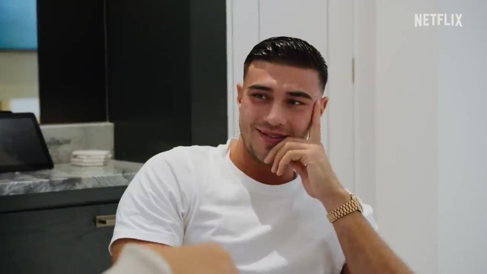 a man in a white shirt with a gold watch on his wrist