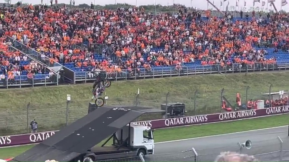 a man riding a bike on a ramp in front of a qatar airways sign