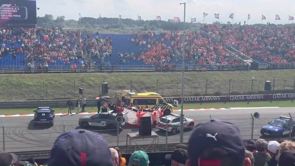 a crowd watching a race with a qatar airways banner