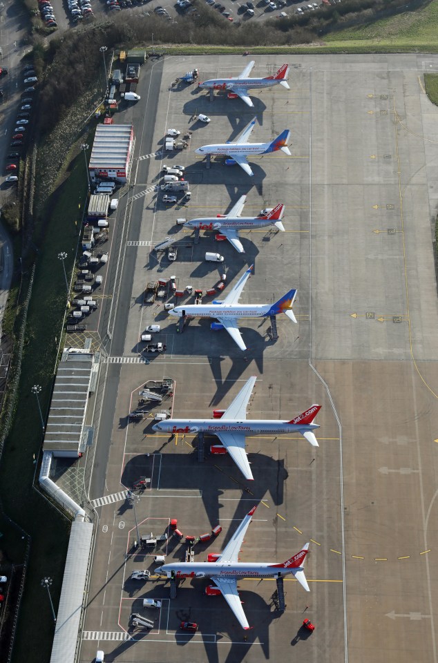 several planes are parked on a runway including one from southwest