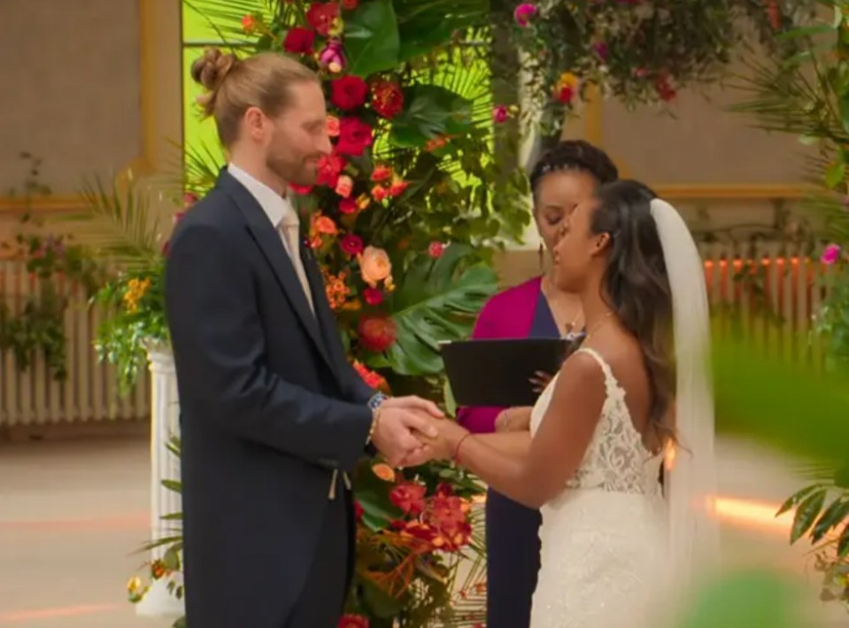 a bride and groom hold hands during their wedding ceremony