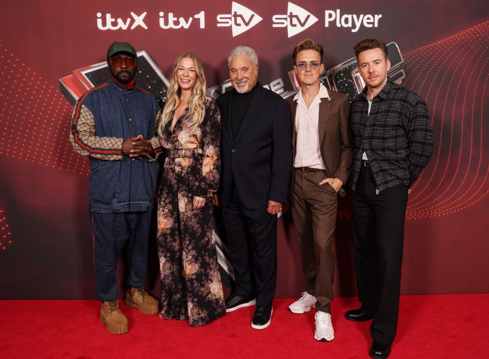 a group of people standing on a red carpet in front of a sign that says itv player