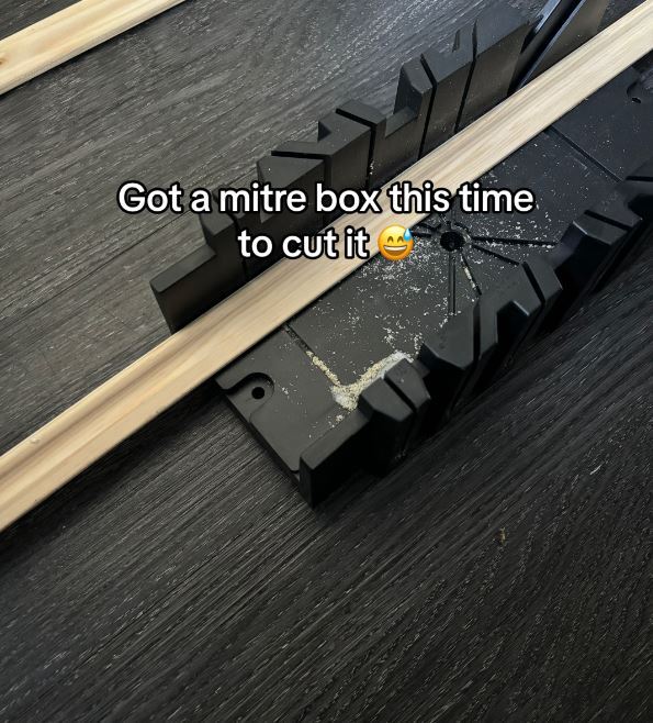 a mitre box is being used to cut a piece of wood