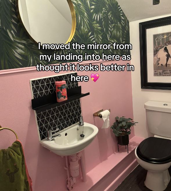 a bathroom with pink walls a sink and a toilet