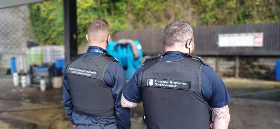 two men wearing vests that say immigration enforcement on them