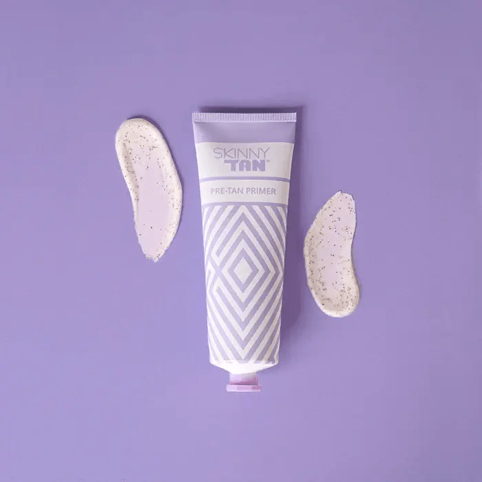 a tube of skinny tan pre tan primer on a purple surface